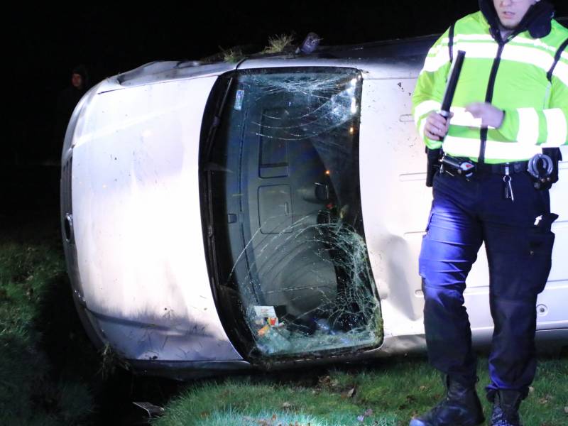 Bestelbus vliegt uit de bocht en belandt op zijkant, twee aanhoudingen