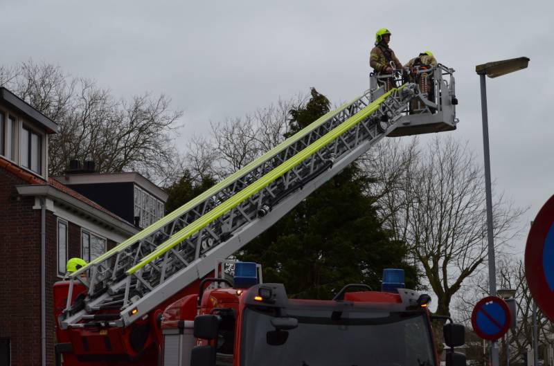 Brandweer zet dakrand vweer vast