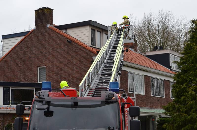 Brandweer zet dakrand vweer vast