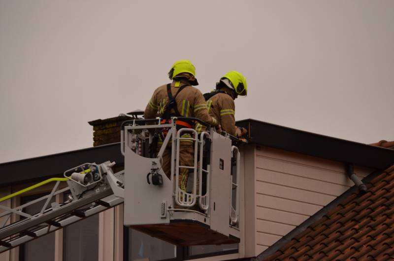 Brandweer zet dakrand vweer vast