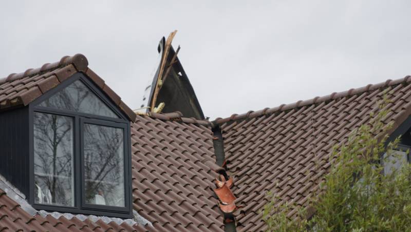 Dak waait van woning en belandt op ander dak