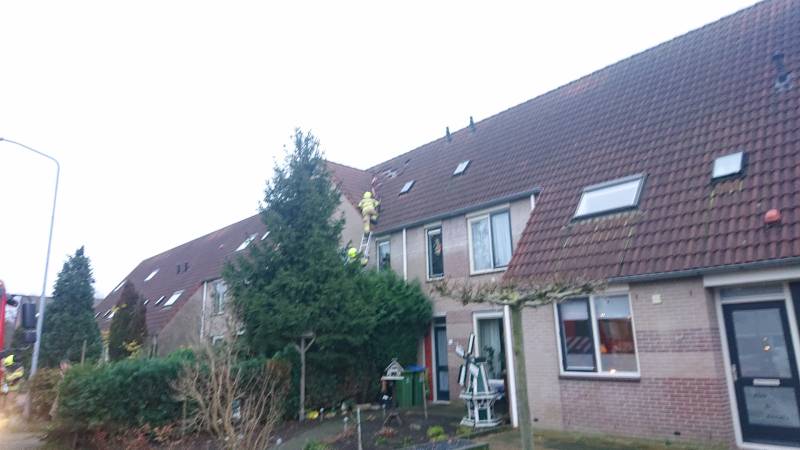 Dakpannen vliegen van woning