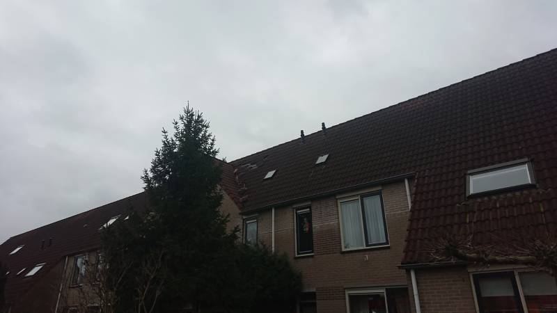 Dakpannen vliegen van woning