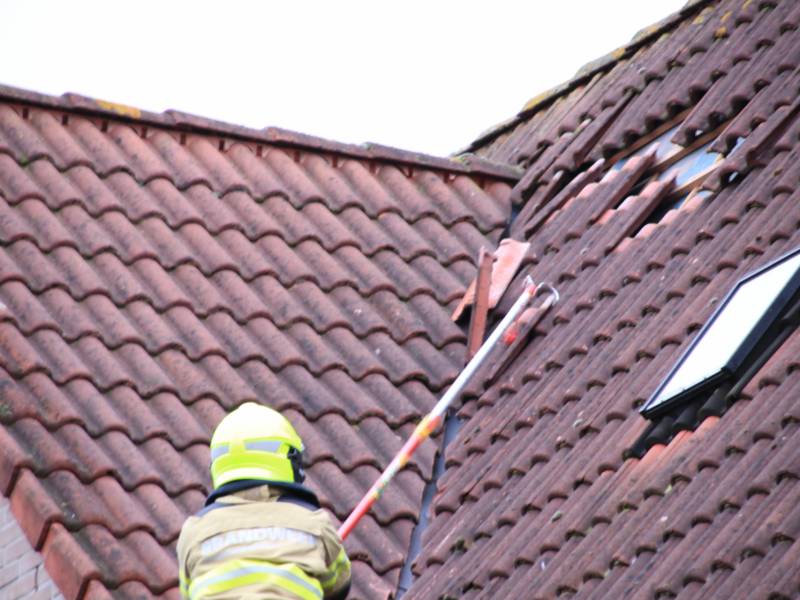 Dakpannen vliegen van woning