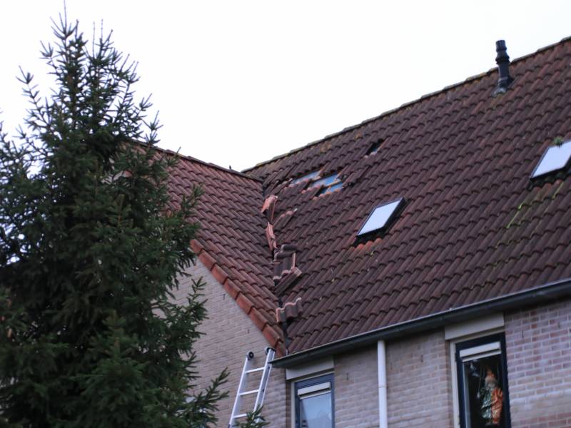 Dakpannen vliegen van woning