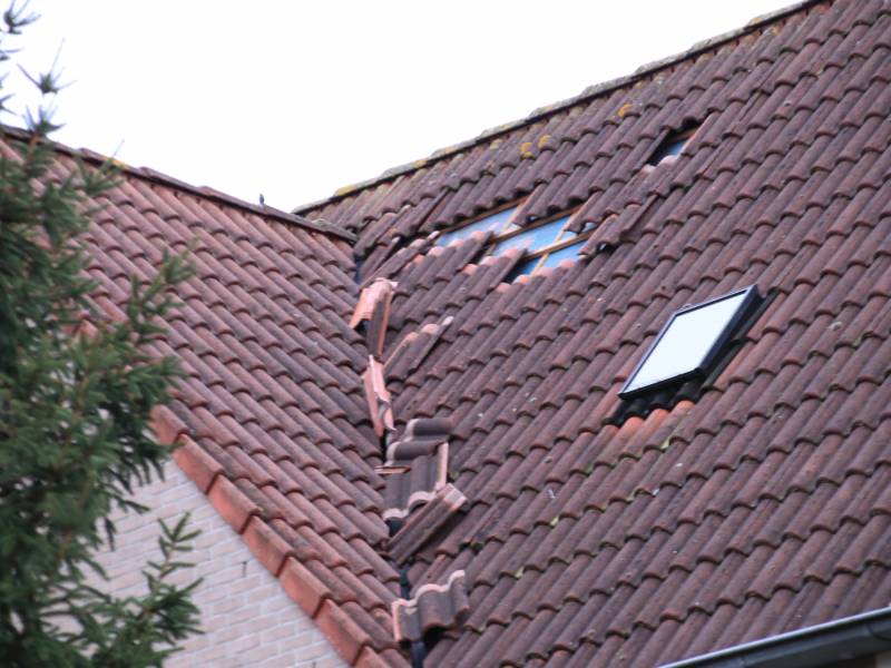 Dakpannen vliegen van woning