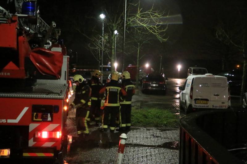 Brandweer druk met losse dakdelen op bedrijfspand