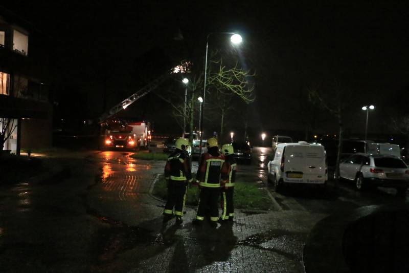 Brandweer druk met losse dakdelen op bedrijfspand