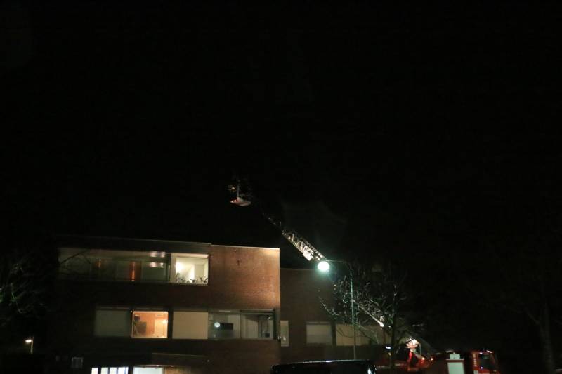 Brandweer druk met losse dakdelen op bedrijfspand