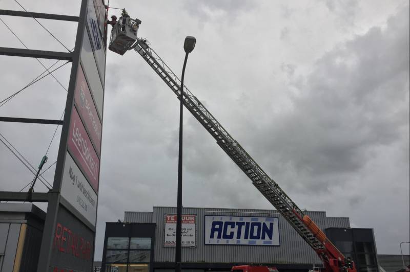 Deel van reclamebord dreigt weg te waaien