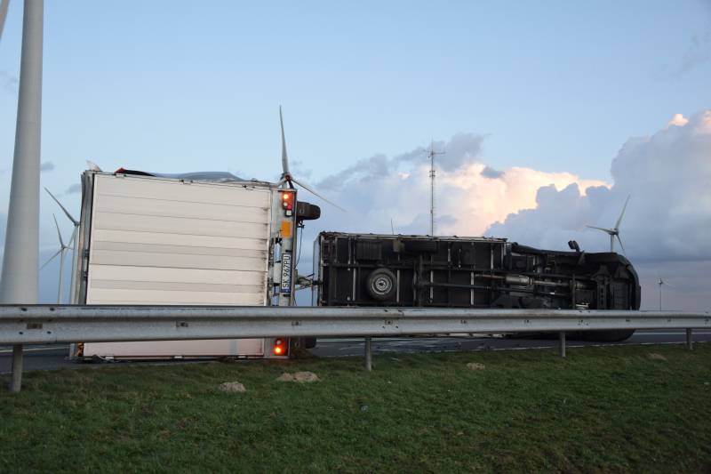 Lege vrachtwagen gekanteld door harde wind op Philipsdam
