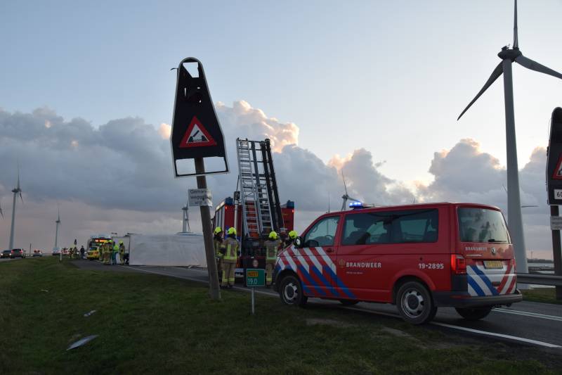 Lege vrachtwagen gekanteld door harde wind op Philipsdam