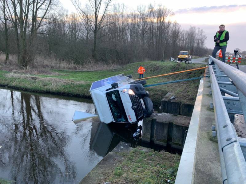 Bestelbus raakt van de weg en belandt te water