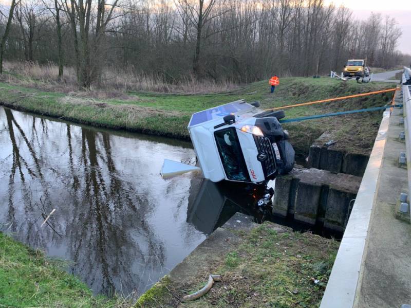 Bestelbus raakt van de weg en belandt te water