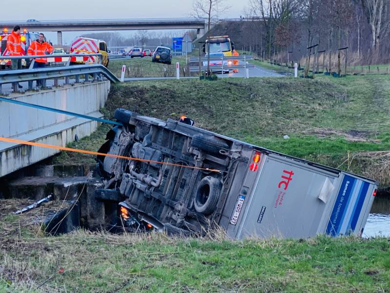 Bestelbus raakt van de weg en belandt te water