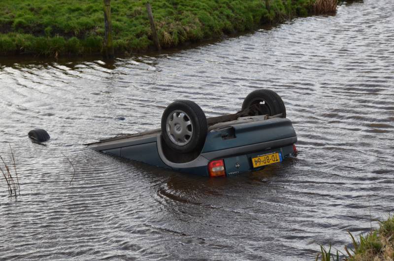 Auto slaat over de kop en raakt te water