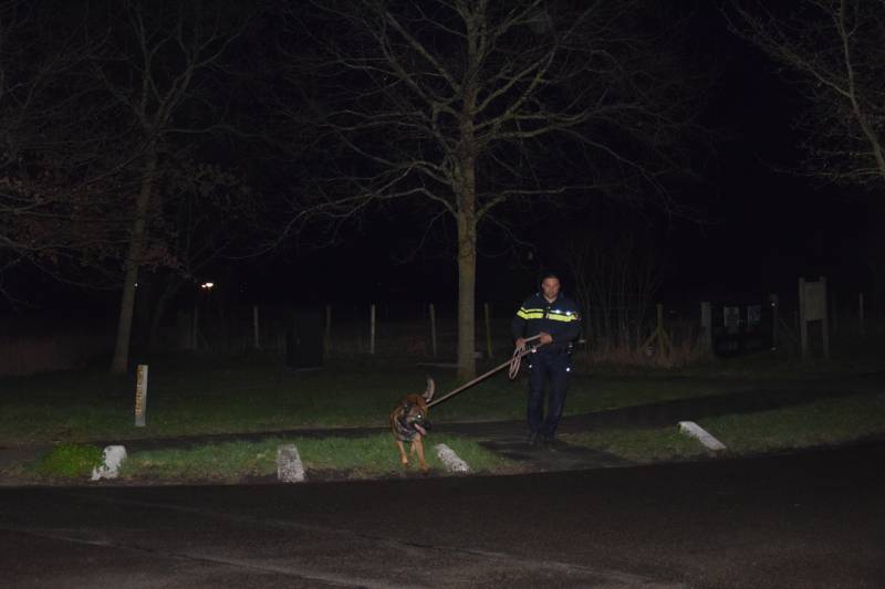Politieauto en personenauto beschadigd door stenen op rijbaan