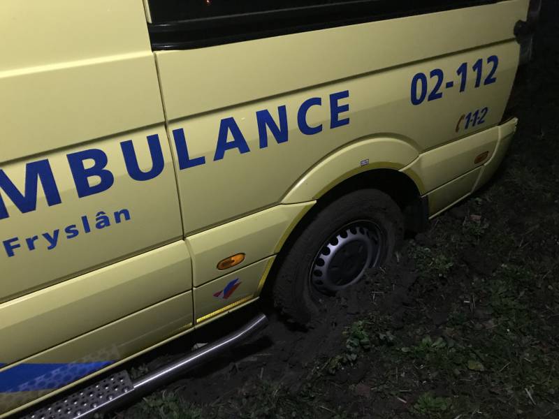 Ambulance komt vast te zitten in grasveld