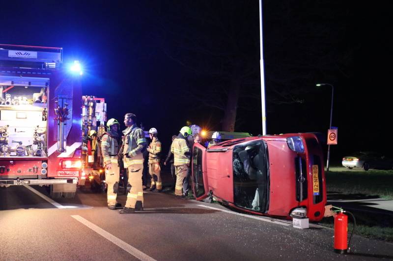 Auto op zijn kant na botsing tegen lantarenpaal