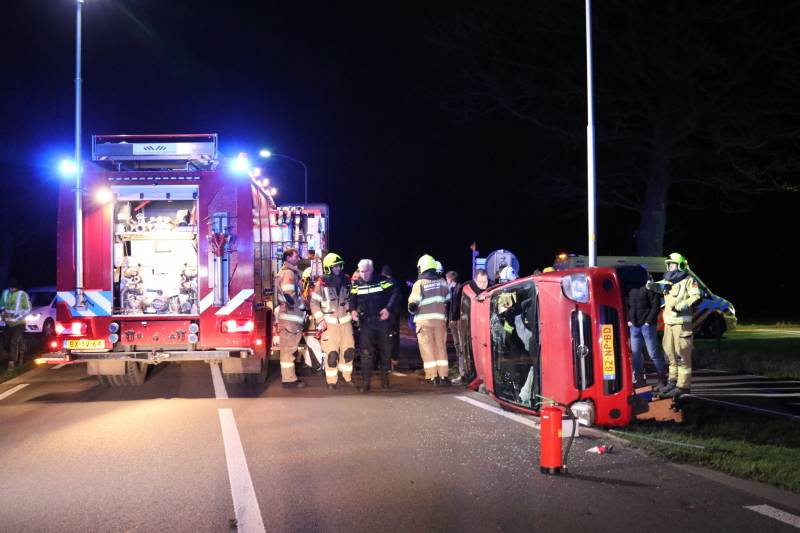 Auto op zijn kant na botsing tegen lantarenpaal