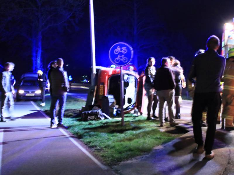 Auto op zijn kant na botsing tegen lantarenpaal