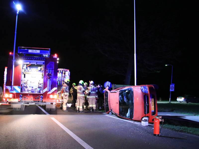 Auto op zijn kant na botsing tegen lantarenpaal