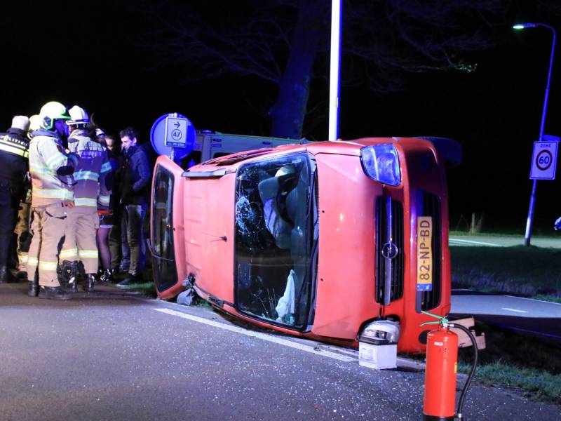 Auto op zijn kant na botsing tegen lantarenpaal