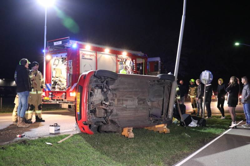 Auto op zijn kant na botsing tegen lantarenpaal