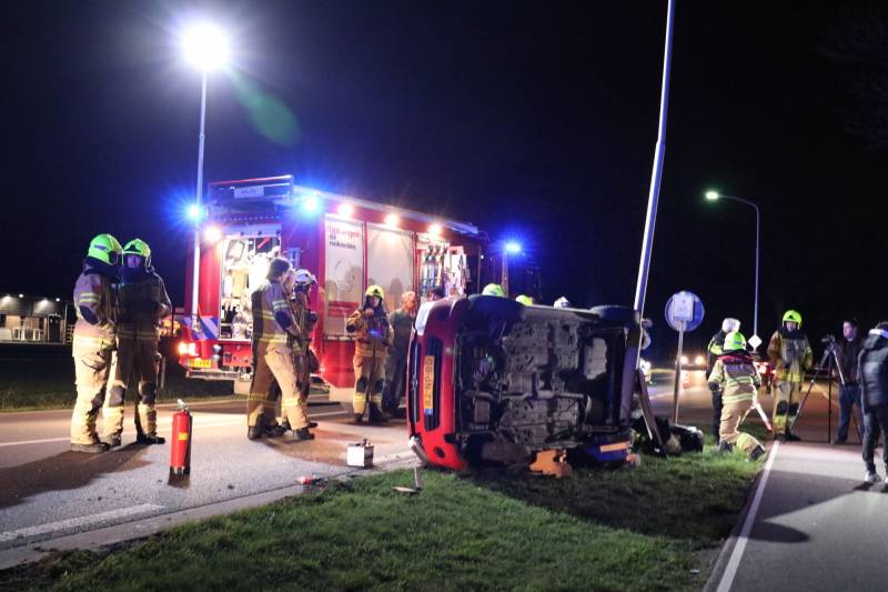 Auto op zijn kant na botsing tegen lantarenpaal