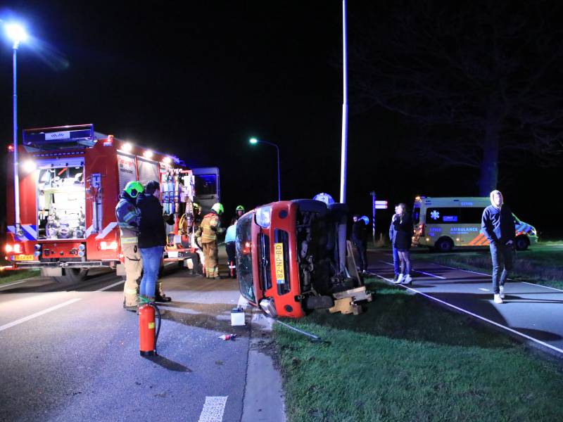 Auto op zijn kant na botsing tegen lantarenpaal