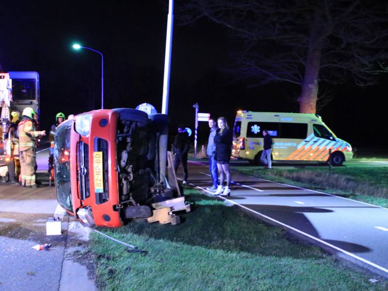 Auto op zijn kant na botsing tegen lantarenpaal