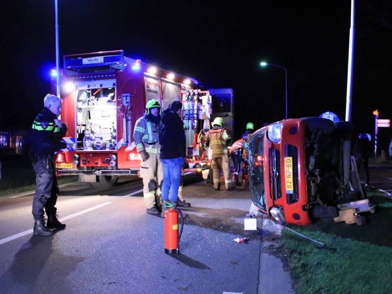 Auto op zijn kant na botsing tegen lantarenpaal