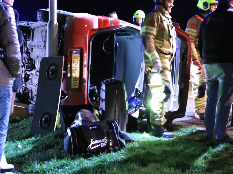 Auto op zijn kant na botsing tegen lantarenpaal