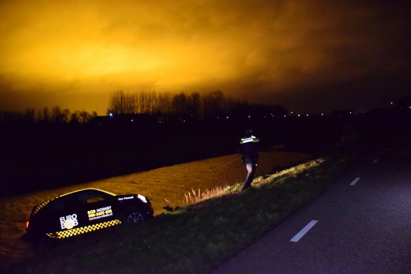 Auto belandt in sloot na botsing met hek
