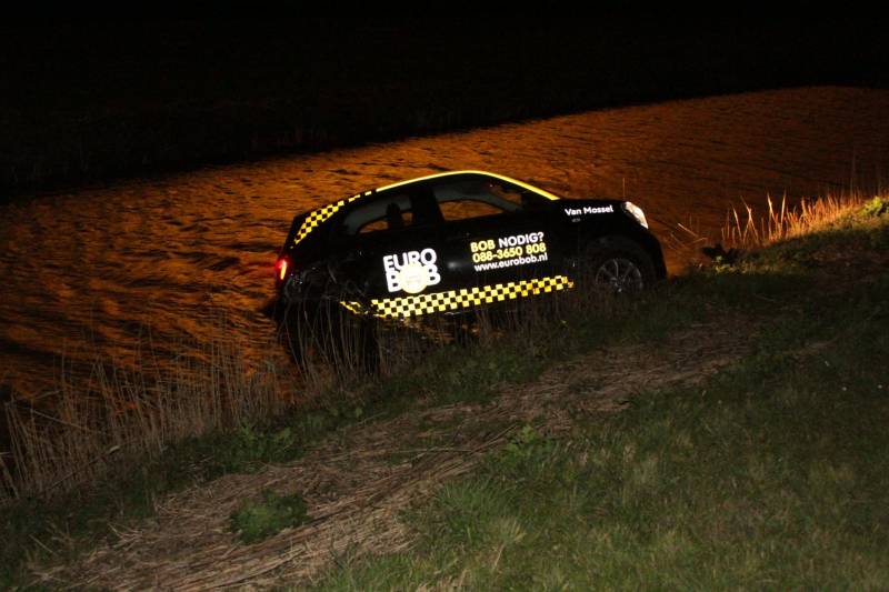 Auto belandt in sloot na botsing met hek