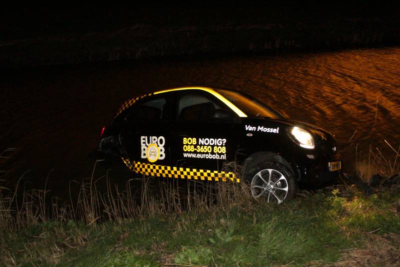 Auto belandt in sloot na botsing met hek