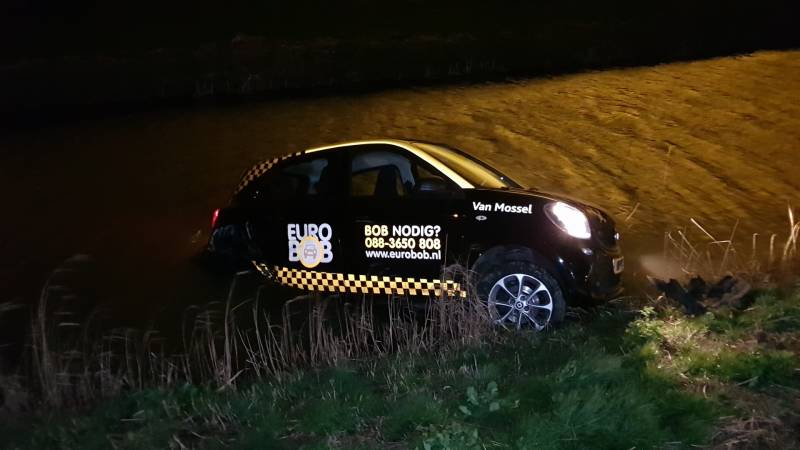 Auto belandt in sloot na botsing met hek