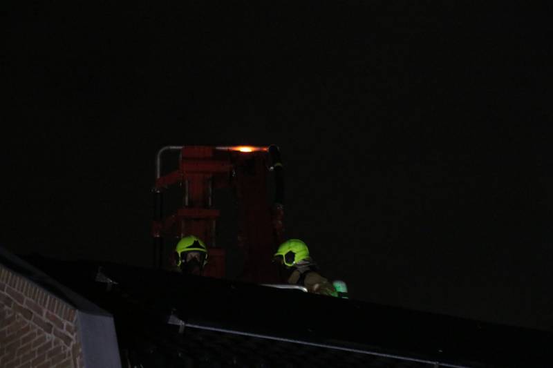 Vlammen slaan uit schoorsteen van woning