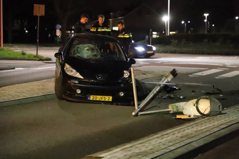 Auto ramt lantaarnpaal op rotonde
