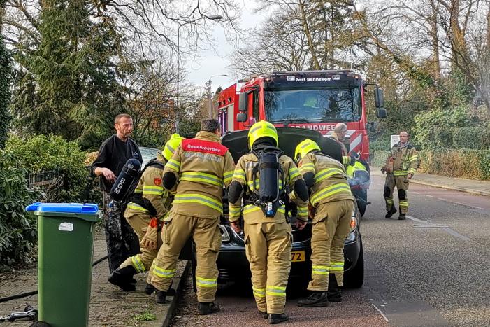 Rook onder de motorkap van de auto