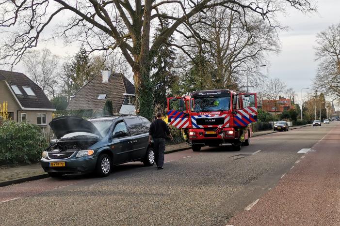 Rook onder de motorkap van de auto