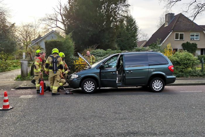 Rook onder de motorkap van de auto
