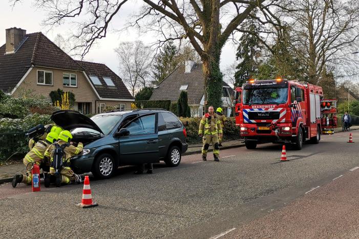 Rook onder de motorkap van de auto