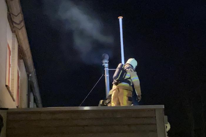 Brand in schoorsteenpijp van palletkachel achter woning