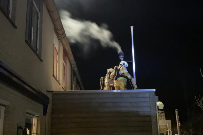 Brand in schoorsteenpijp van palletkachel achter woning
