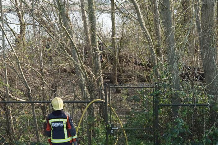 Bosschage langs rivier de Lek in brand