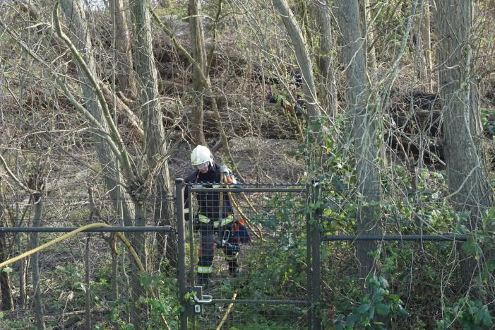 Bosschage langs rivier de Lek in brand