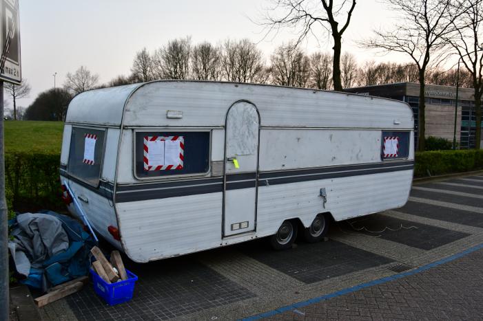 Handhaving sleept caravan met protesttekst weg van parkeerterrein gemeentewerf