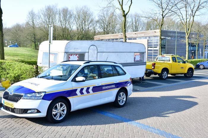 Handhaving sleept caravan met protesttekst weg van parkeerterrein gemeentewerf