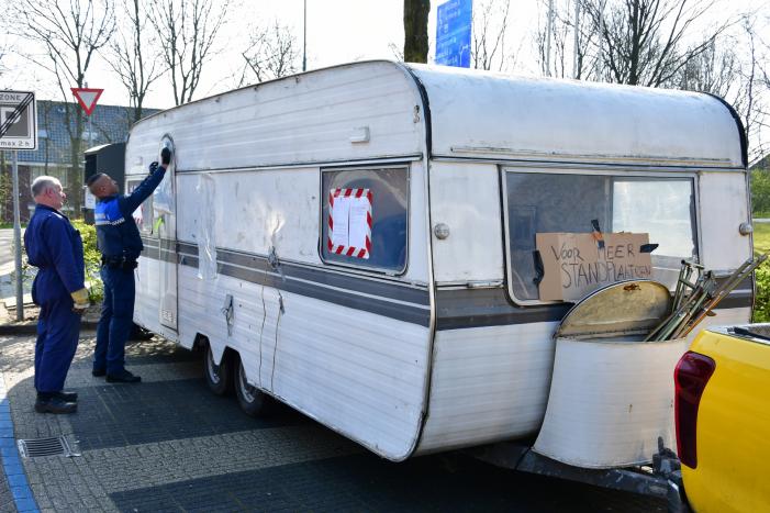 Handhaving sleept caravan met protesttekst weg van parkeerterrein gemeentewerf